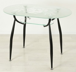 Стеклянный стол с узором на стекле на черных опорах с прозрачной полочкой.
