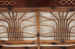 Диван двухместный из ротанга с деревянными вставками и подушками. Фрагмент спинки с элементами плетения.